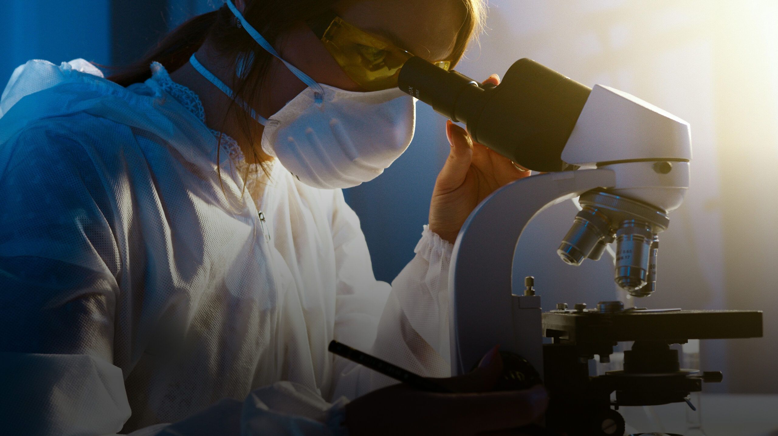 Headerfoto voor de case study van database-optimalisatie bij Pathan. Laborant kijkt door een microscoop.
