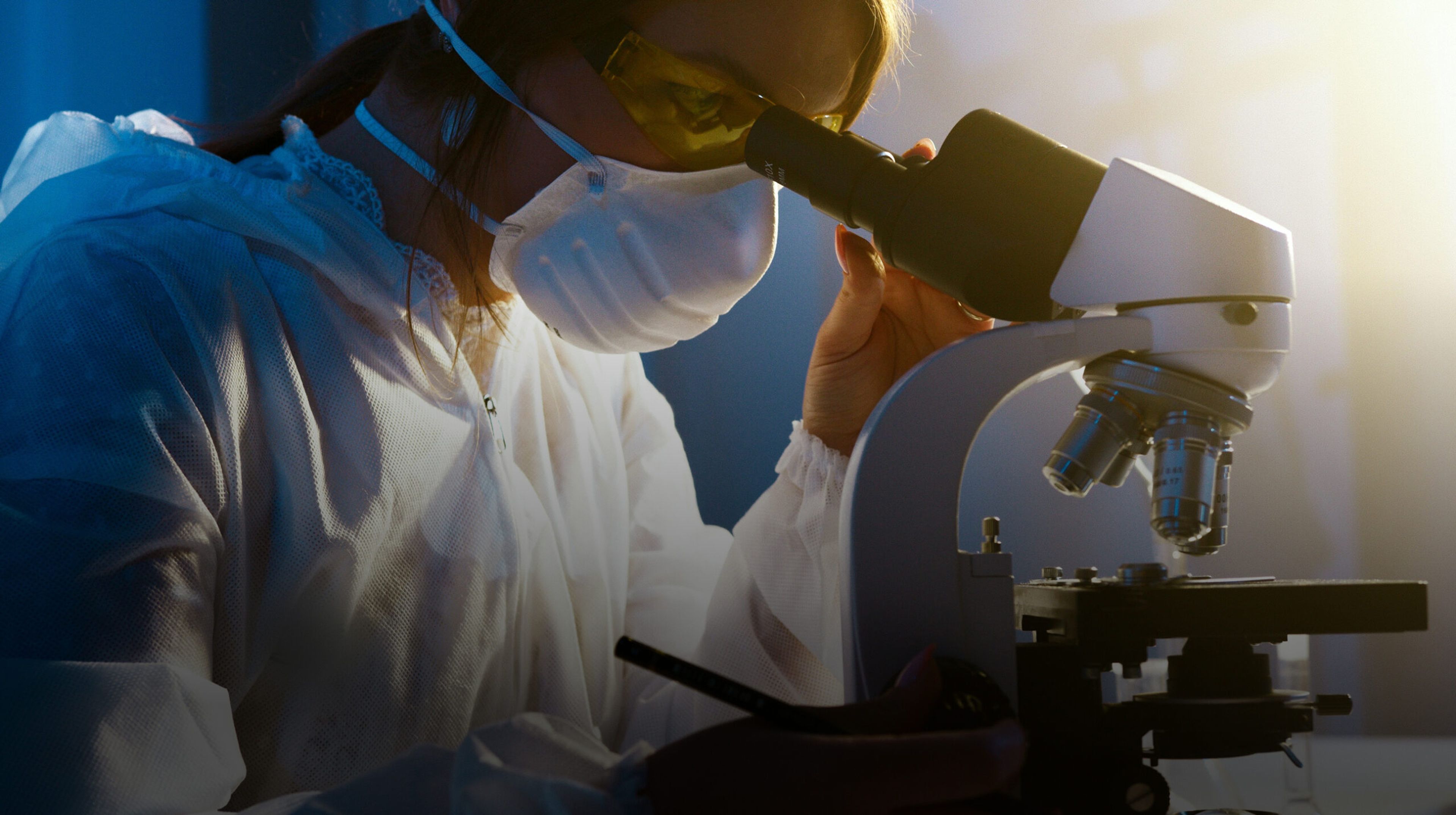 Headerfoto voor de case study van database-optimalisatie bij Pathan. Laborant kijkt door een microscoop.