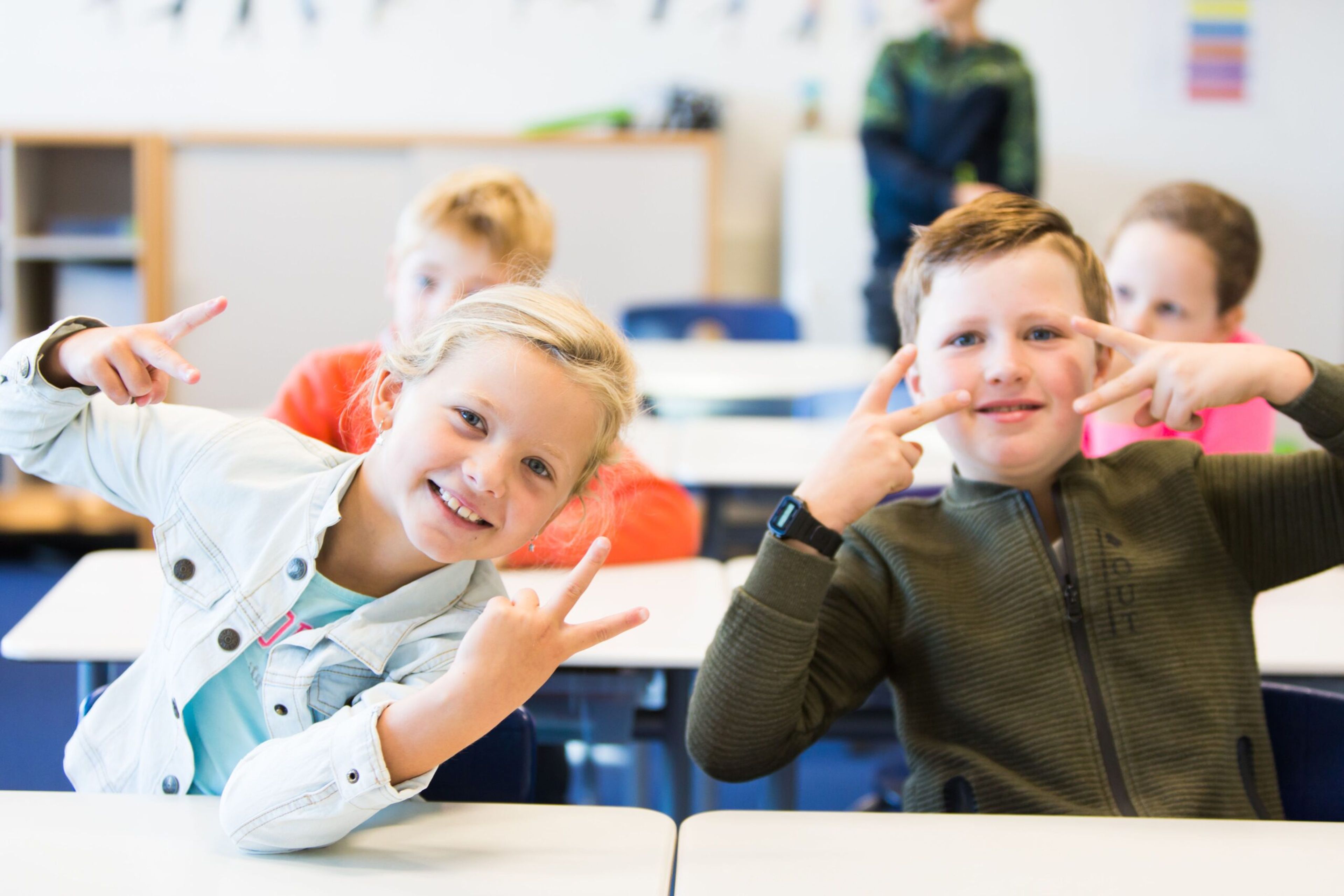 Leerlingen blij aan hun tafeltje in de klas - ParnasSys